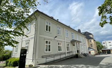 en hvit bygning med svart rekkverk