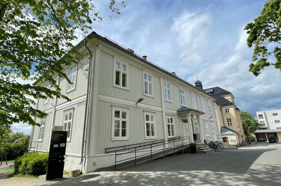 en hvit bygning med svart rekkverk