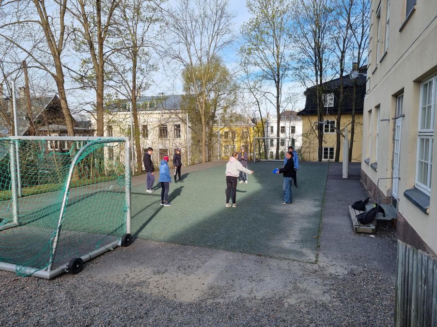 en gruppe mennesker som går på en sti mellom bygninger en gruppe mennesker som går på en sti mellom bygninger