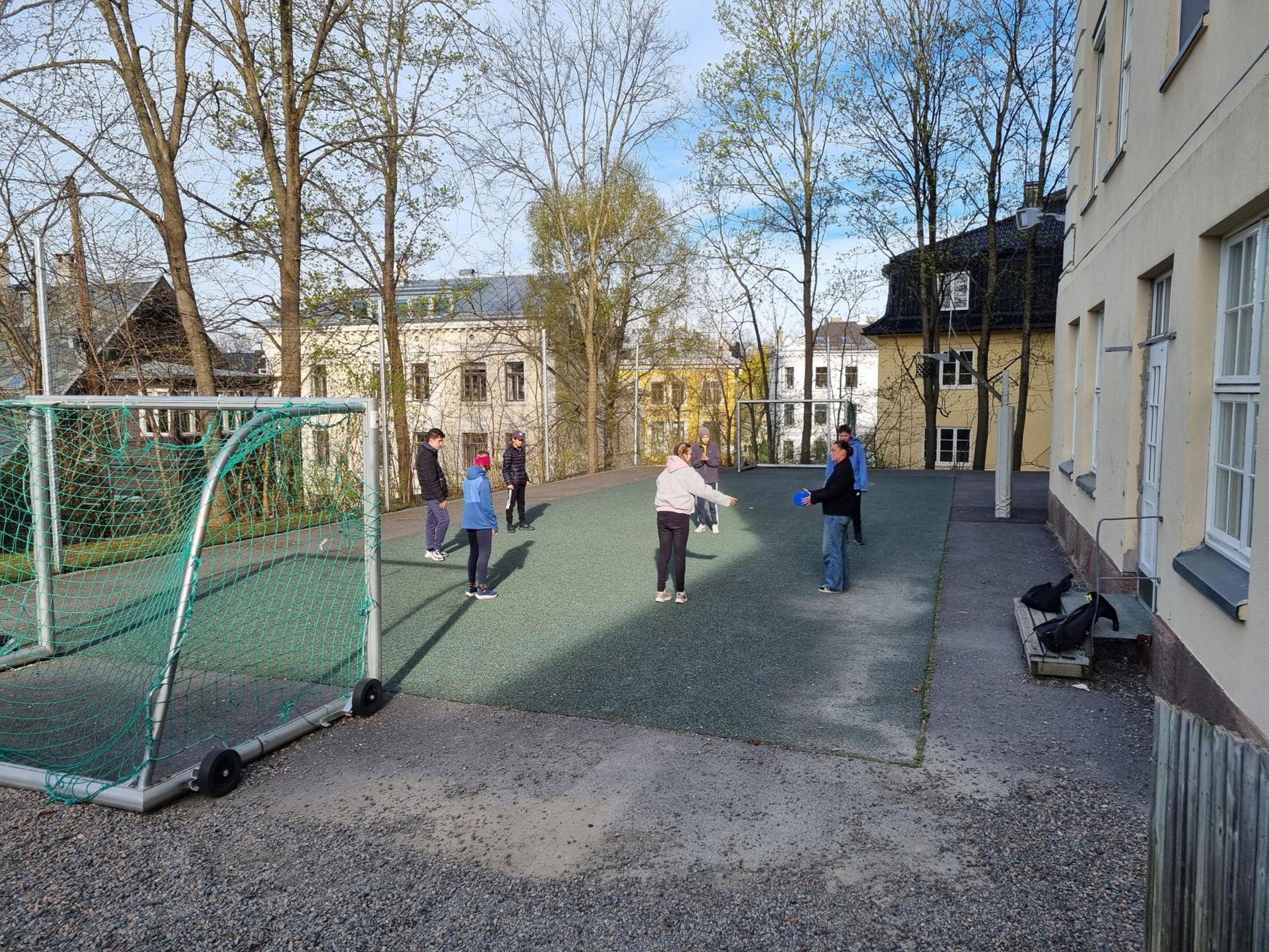 en gruppe mennesker som går på en sti mellom bygninger en gruppe mennesker som går på en sti mellom bygninger