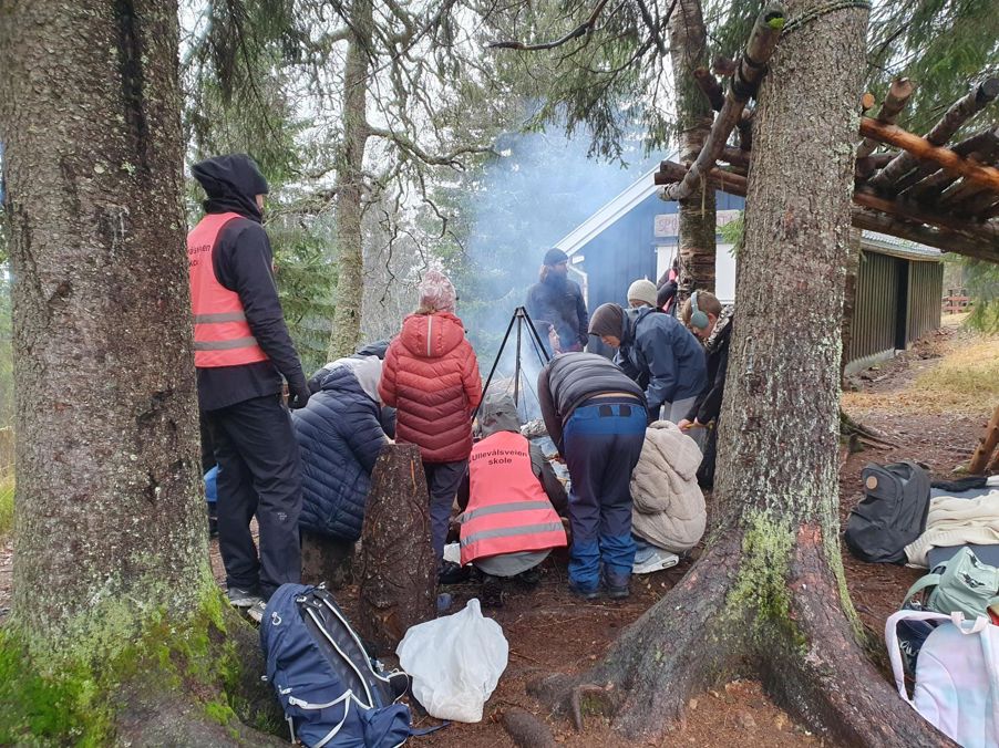 en gruppe mennesker som sitter på en stein i skogen en gruppe mennesker som sitter på en stein i skogen