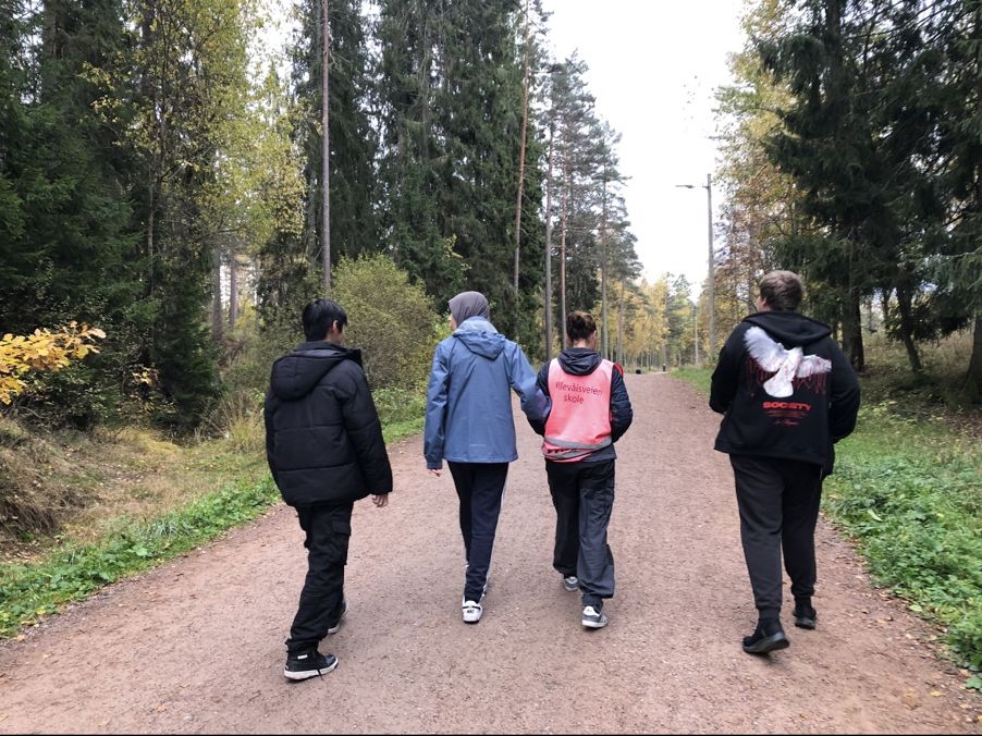 en gruppe mennesker som går på en sti i skogen en gruppe mennesker som går på en sti i skogen