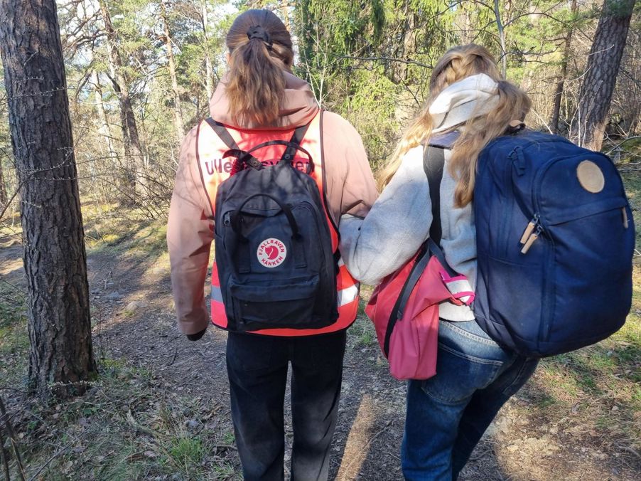En gruppe mennesker som går i skogen En gruppe mennesker som går i skogen