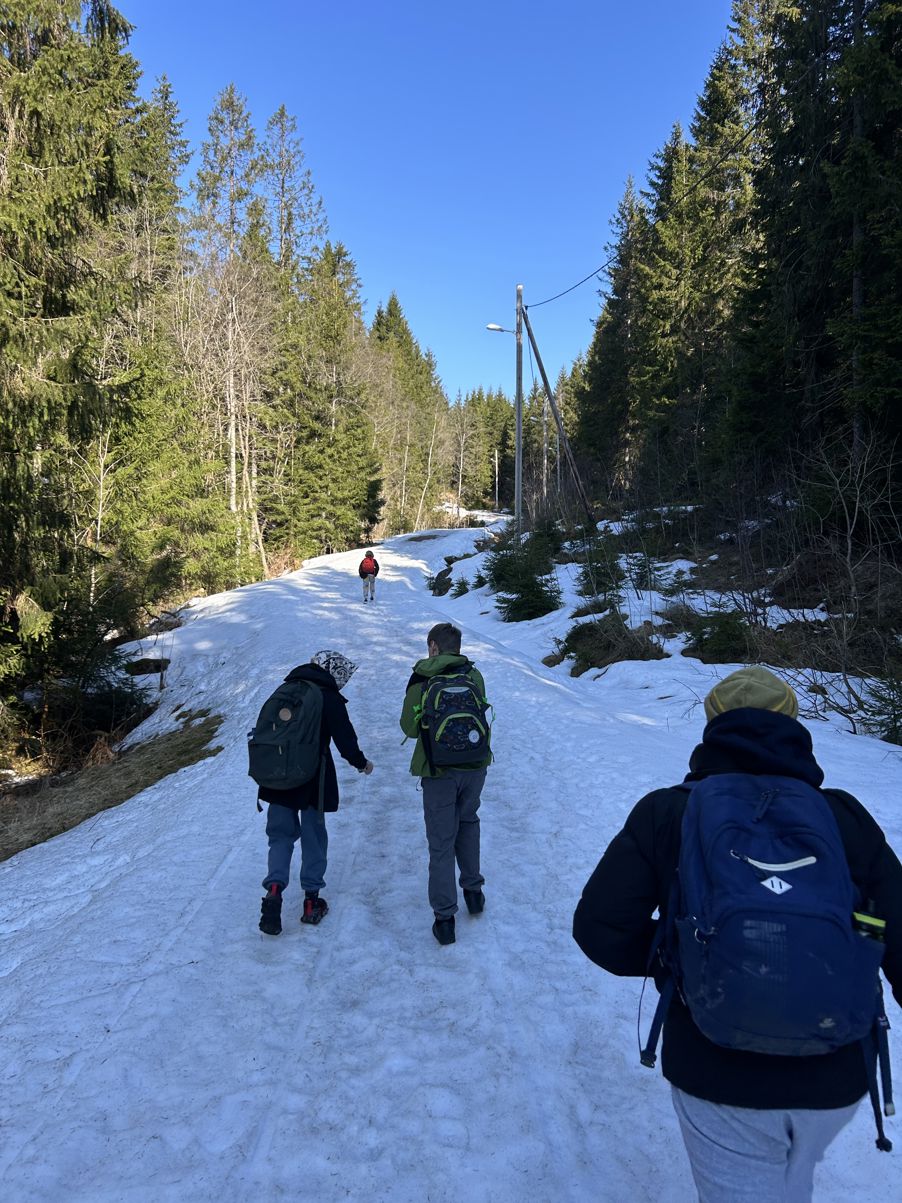 En gruppe mennesker som står på en snødekt ås En gruppe mennesker som står på en snødekt ås